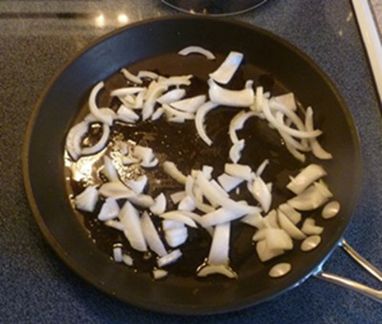 Sliced onions frying in a pan